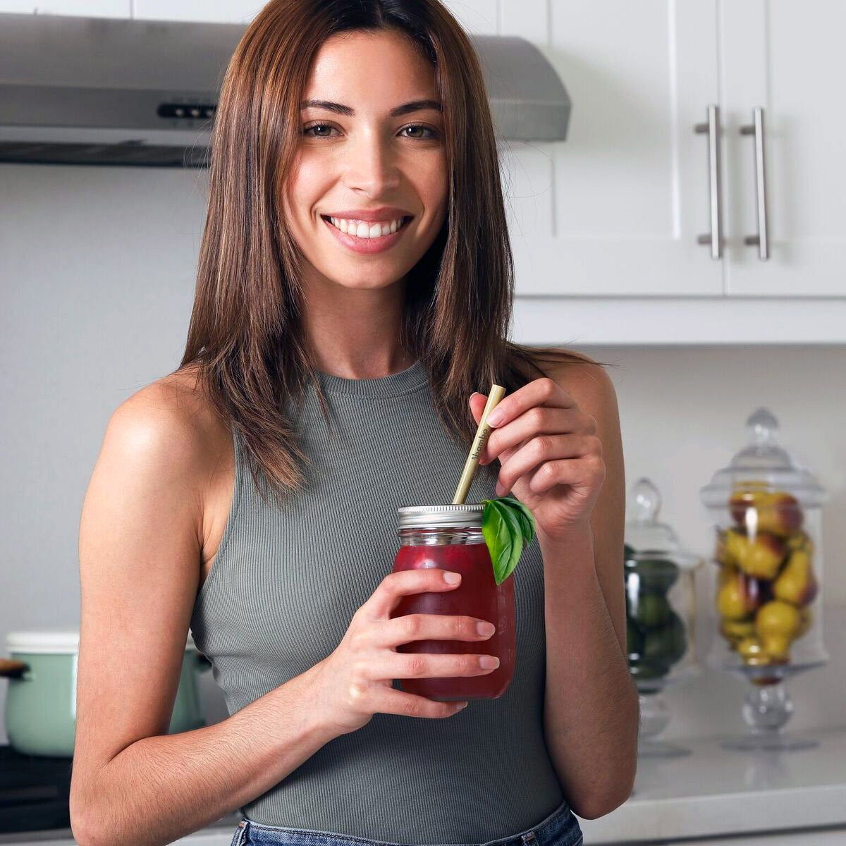 woman drinking from a bamboo straw