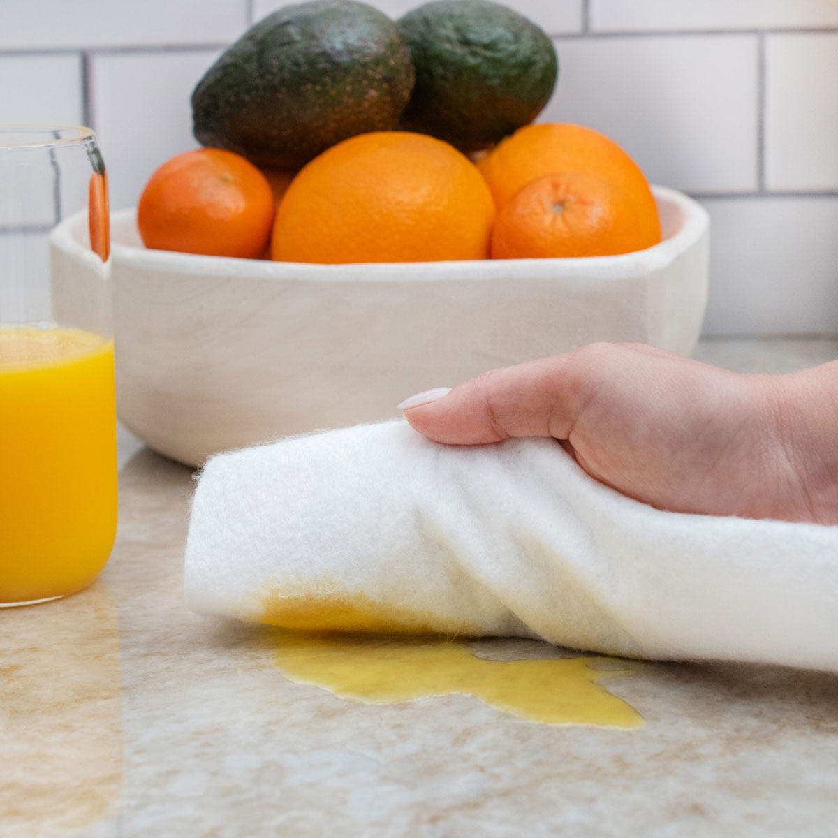 Reusable bamboo paper towel cleaning a spill on a kitchen counter