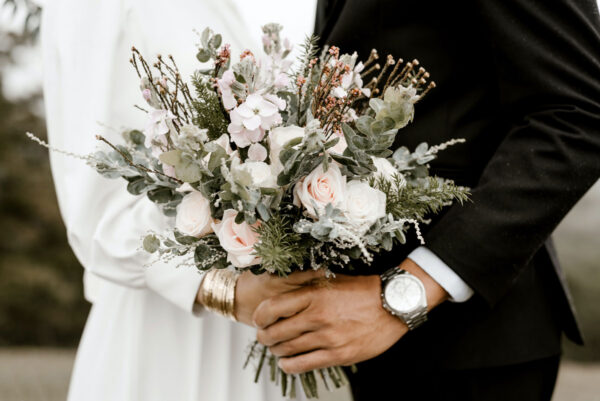 Bride and groom holding an elegant wedding flower bouquet